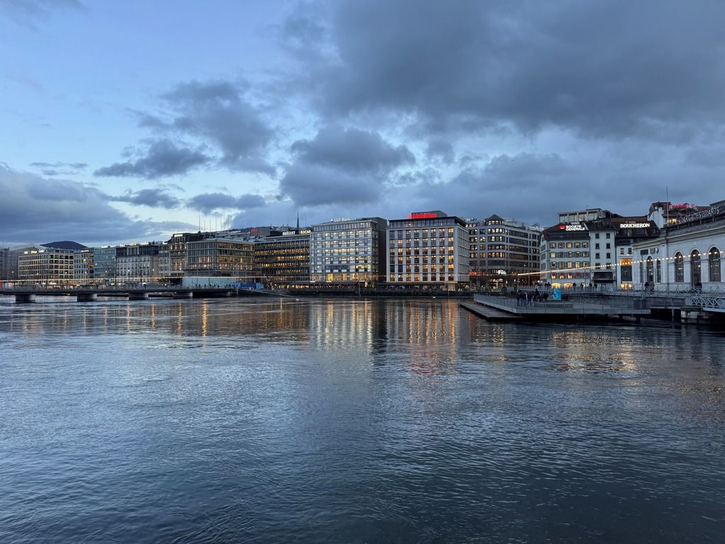 The small Geneva harbor with its illuminated signs on the roofs